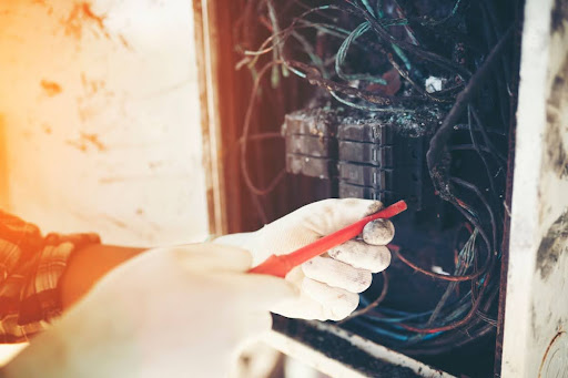 Electrician working on a burnt out electrical panel.