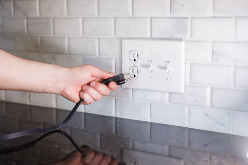 Electrical outlet clicking as homeowner plugs in an appliance.